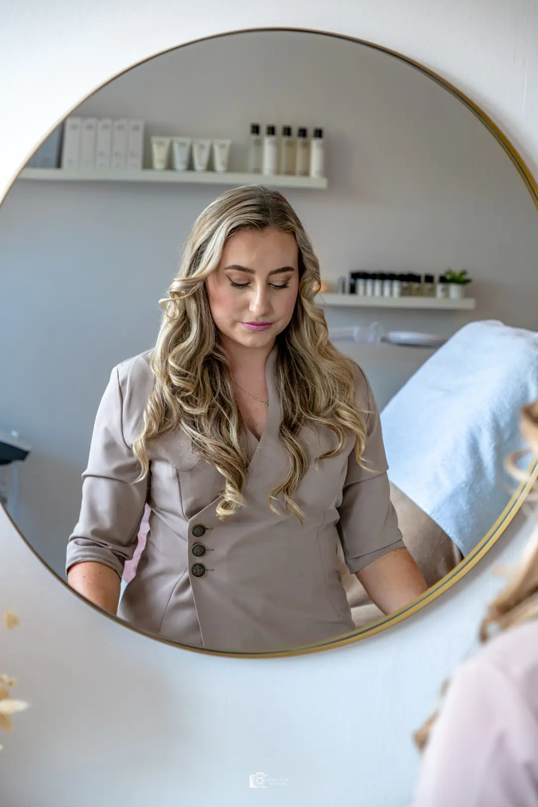 Celine in de ronde spiegel van haar salon.